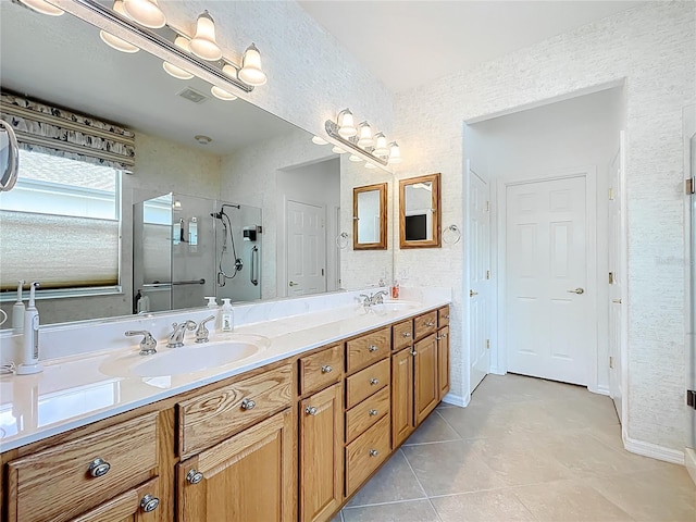 full bathroom featuring a shower stall, tile patterned floors, double vanity, and a sink