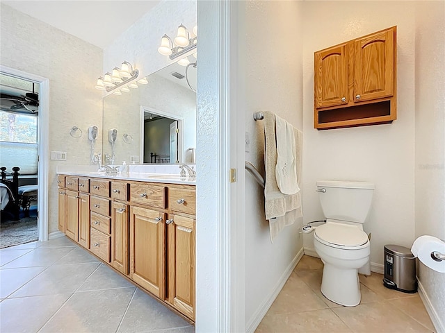 ensuite bathroom with ensuite bathroom, double vanity, a sink, and tile patterned flooring