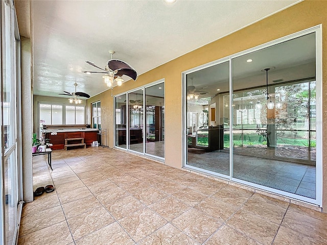 unfurnished sunroom with a jacuzzi and a ceiling fan