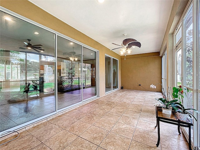 unfurnished sunroom featuring a healthy amount of sunlight and ceiling fan