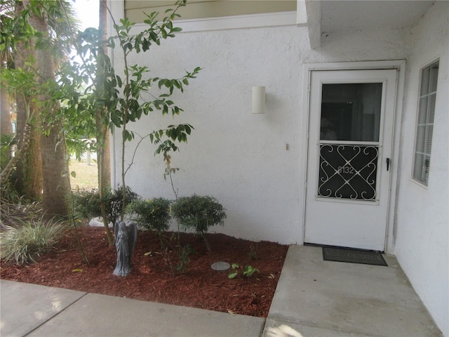 entrance to property featuring stucco siding