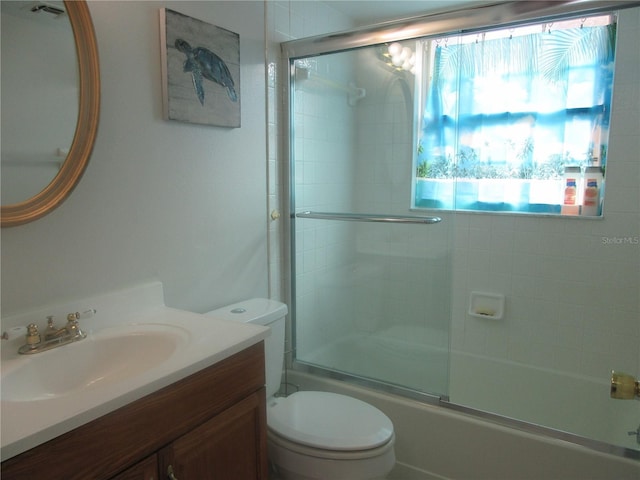 bathroom featuring vanity, toilet, and enclosed tub / shower combo