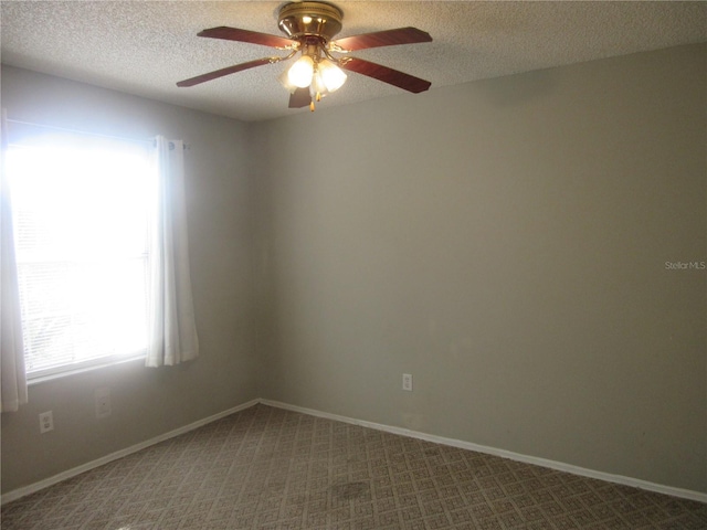 spare room with carpet floors, baseboards, a textured ceiling, and ceiling fan