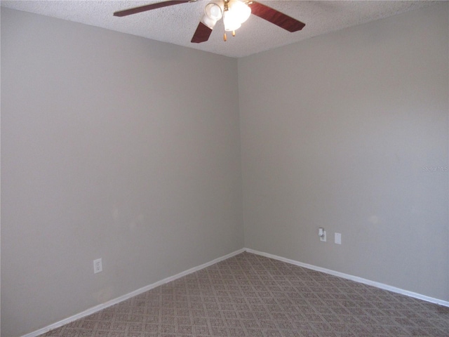 carpeted spare room with ceiling fan, baseboards, and a textured ceiling