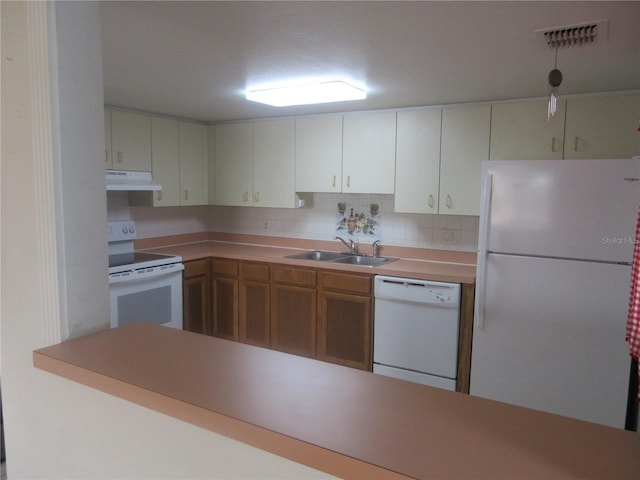 kitchen with a sink, visible vents, backsplash, white appliances, and under cabinet range hood