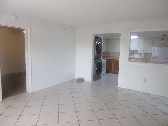 interior space featuring stacked washer / dryer and a textured ceiling