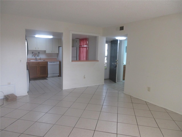 unfurnished room featuring visible vents, light tile patterned floors, and a sink