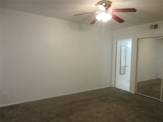 unfurnished bedroom with a closet, connected bathroom, ceiling fan, carpet floors, and visible vents