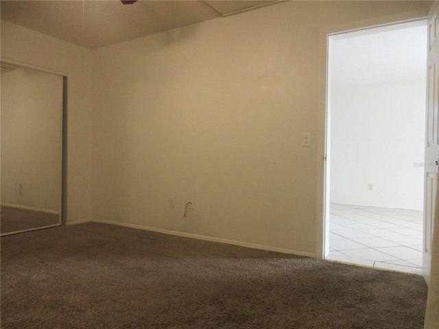 unfurnished bedroom featuring baseboards, carpet flooring, and a closet