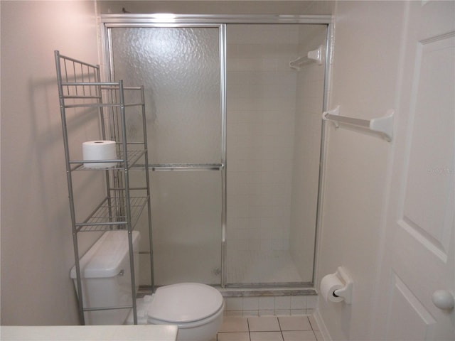 full bath featuring toilet, tile patterned floors, and a stall shower
