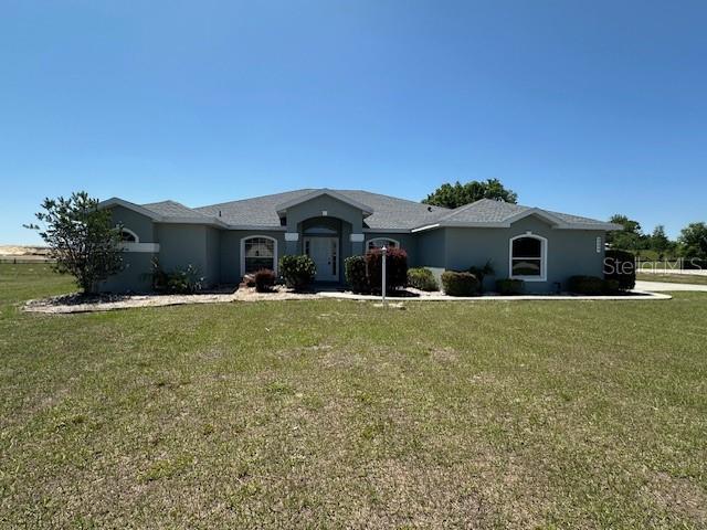 9934 SE 64th Ave, Belleview, FL 34420 - ranch-style house featuring stucco siding and a front lawn