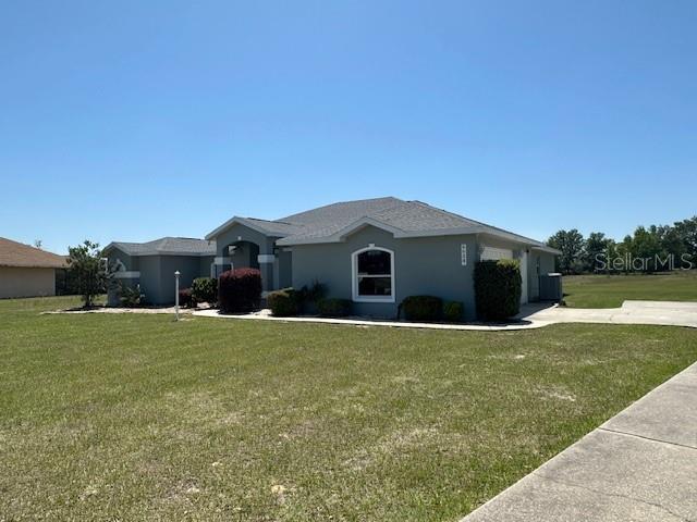 9934 SE 64th Ave, Belleview, FL 34420 - ranch-style house with an attached garage, concrete driveway, and a front yard