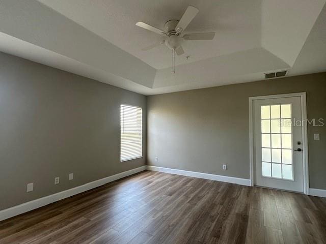 9934 SE 64th Ave, Belleview, FL 34420 - unfurnished room with baseboards, dark wood finished floors, visible vents, a tray ceiling, and ceiling fan