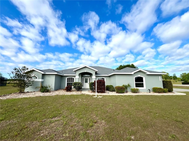9934 SE 64th Ave, Belleview, FL 34420 - ranch-style home with a shingled roof, stucco siding, and a front lawn