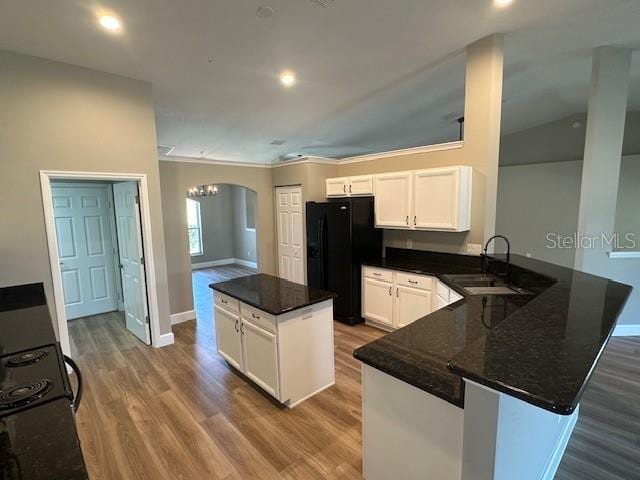 9934 SE 64th Ave, Belleview, FL 34420 - kitchen featuring arched walkways, freestanding refrigerator, a sink, and wood finished floors