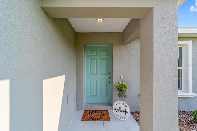 entrance to property with stucco siding