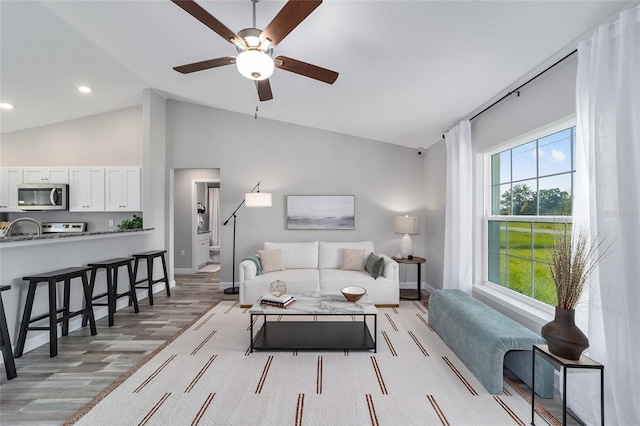 living room with recessed lighting, light wood finished floors, baseboards, and a ceiling fan
