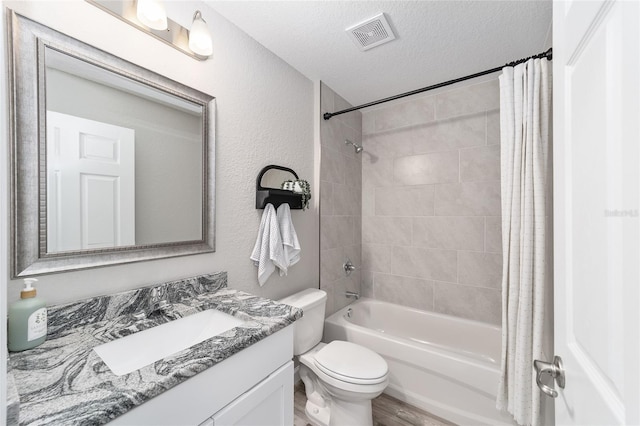bathroom featuring a textured ceiling, shower / bathtub combination with curtain, vanity, visible vents, and toilet