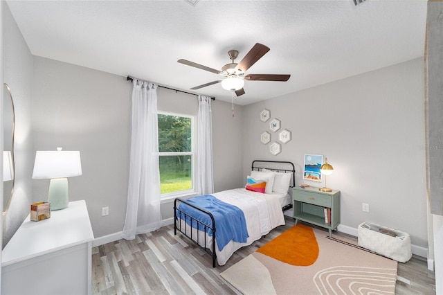 bedroom featuring light wood-type flooring, ceiling fan, and baseboards
