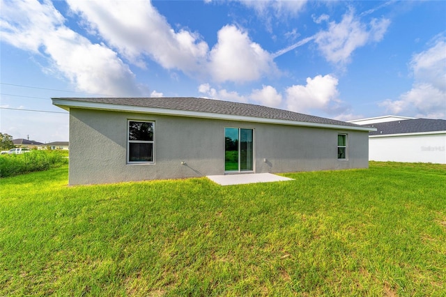back of house with a patio, stucco siding, and a lawn