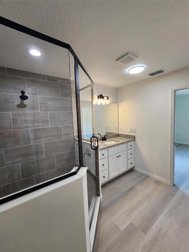 22764 SW Sea Cliff Ave, Dunnellon, FL 34431 - bathroom featuring a textured ceiling, wood finished floors, a shower stall, vanity, and recessed lighting