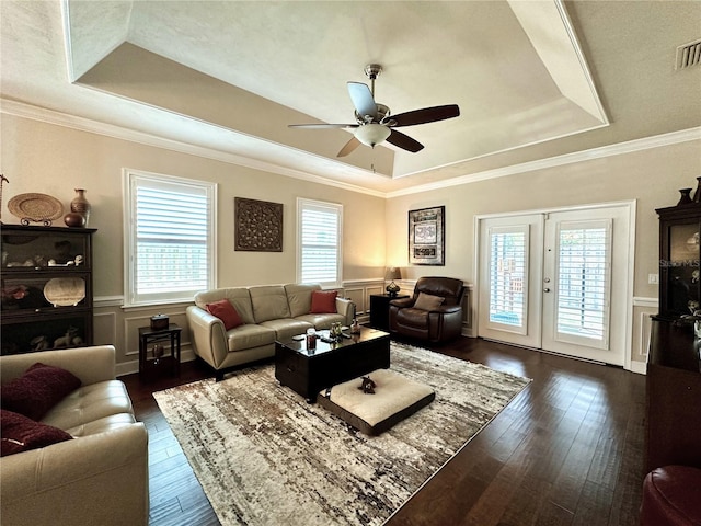 3488 NW 26th St, Gainesville, FL 32605 - living room featuring dark wood-style flooring, a tray ceiling, a ceiling fan, and a healthy amount of sunlight