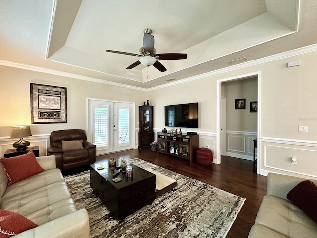 3488 NW 26th St, Gainesville, FL 32605 - living room with a tray ceiling, a ceiling fan, a wainscoted wall, and wood finished floors