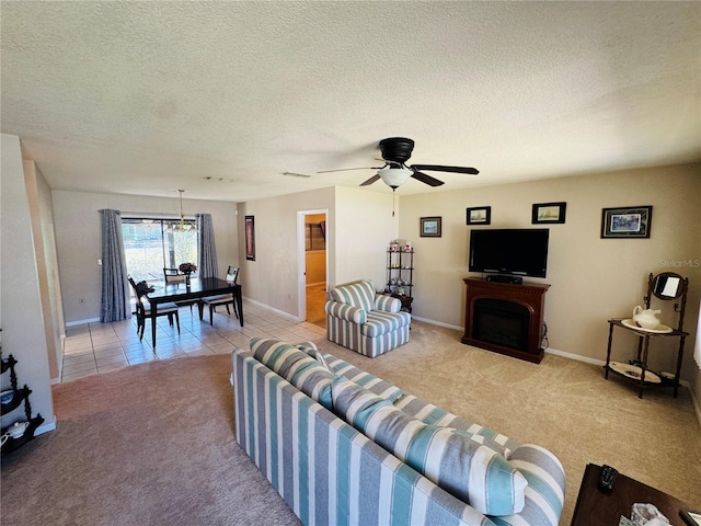 living room with light colored carpet, baseboards, ceiling fan with notable chandelier, and a textured ceiling