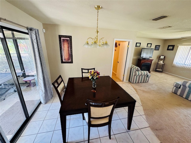 dining space featuring visible vents, baseboards, light tile patterned floors, an inviting chandelier, and light carpet