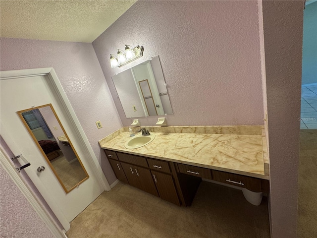 ensuite bathroom with a textured ceiling, a textured wall, ensuite bathroom, and vanity