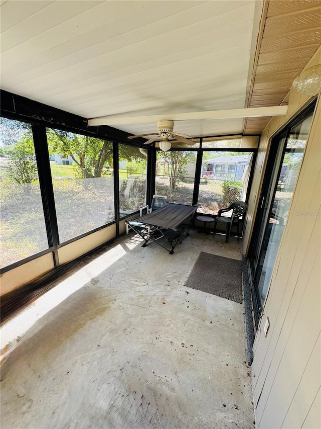 unfurnished sunroom with a ceiling fan