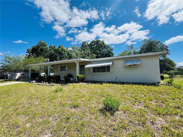 ranch-style house with a front yard, driveway, and a carport
