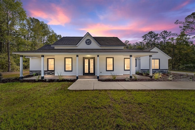 14115 NW 141st Ave, Williston, FL 32696 - back of house at dusk with french doors, covered porch, a yard, and stucco siding