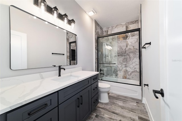 14115 NW 141st Ave, Williston, FL 32696 - bathroom featuring vanity, bath / shower combo with glass door, toilet, and wood finished floors