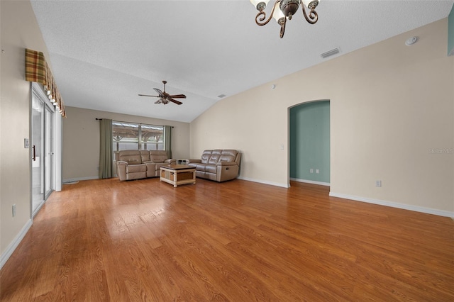 882 Tanglewood Pl, The Villages, FL 32162 - sitting room featuring light wood-type flooring, vaulted ceiling, visible vents, arched walkways, and ceiling fan with notable chandelier