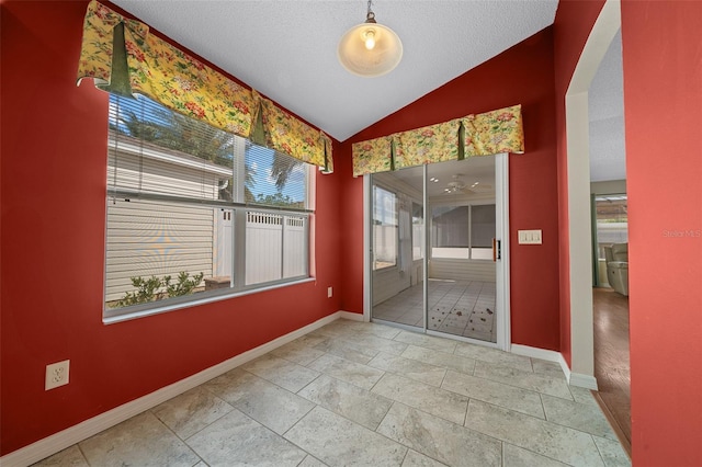 882 Tanglewood Pl, The Villages, FL 32162 - spare room featuring arched walkways, baseboards, vaulted ceiling, and a textured ceiling