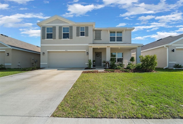 traditional-style home featuring stucco siding, driveway, an attached garage, a front lawn, and covered porch