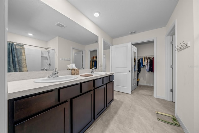 full bathroom featuring a spacious closet, visible vents, and a sink