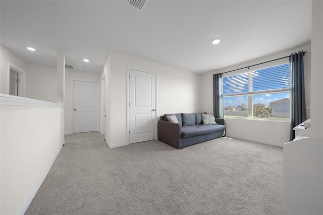 carpeted living area featuring visible vents, baseboards, and recessed lighting