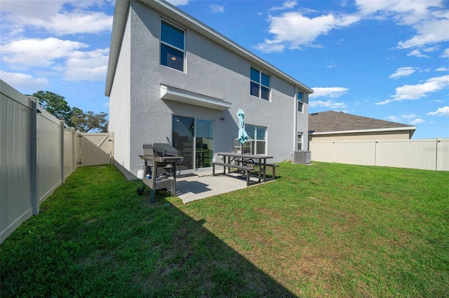 back of house with a yard, a patio, stucco siding, and a fenced backyard
