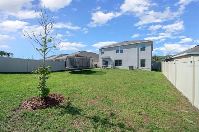 view of yard featuring central AC, a fenced backyard, and a trampoline