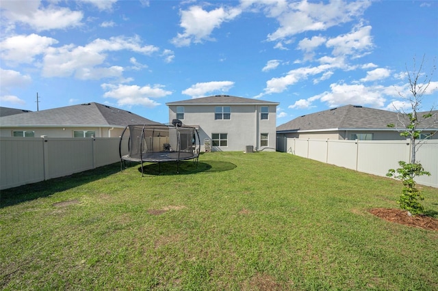 view of yard with a fenced backyard, a trampoline, and central air condition unit