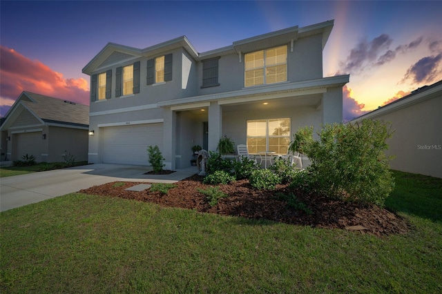 traditional-style home featuring a porch, a garage, stucco siding, and driveway