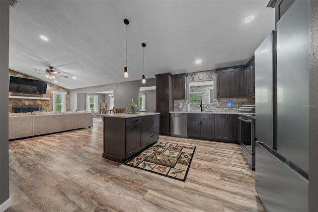 kitchen with light wood-type flooring, ceiling fan, light countertops, and stainless steel appliances