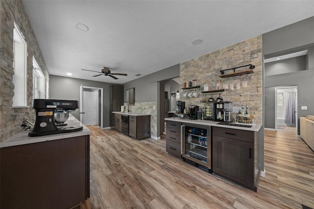 kitchen with light wood finished floors, beverage cooler, light countertops, and a healthy amount of sunlight