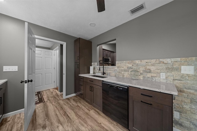 kitchen with dark brown cabinets, black dishwasher, light wood-style floors, visible vents, and a sink
