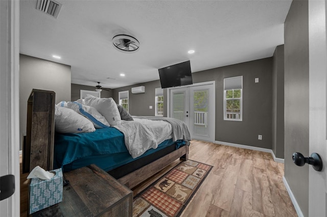bedroom featuring access to outside, visible vents, multiple windows, french doors, and light wood finished floors