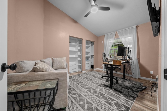 home office featuring baseboards, vaulted ceiling, a ceiling fan, and wood finished floors