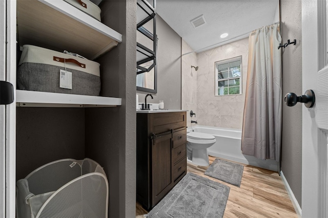 full bathroom featuring visible vents, toilet, shower / bath combo with shower curtain, vanity, and wood finished floors