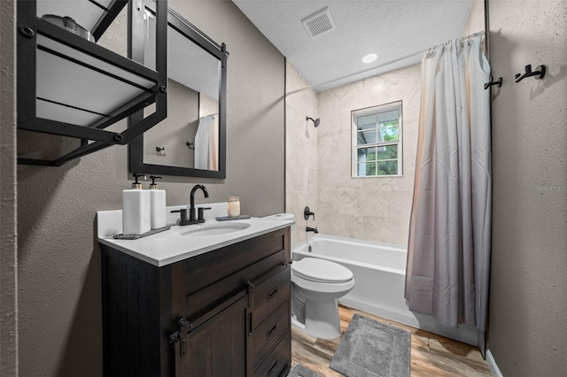 full bath with vanity, shower / tub combo with curtain, toilet, visible vents, and wood finished floors